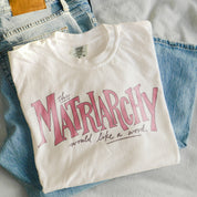 The Matriarchy Would Like a Word Tee in Ivory, folded on jeans