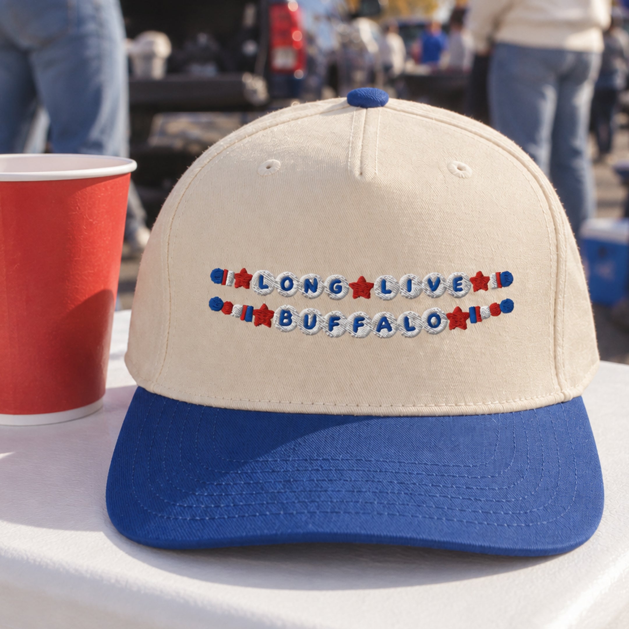 Long Live Buffalo Friendship Bracelet Trucker Hat in Royal/Natural at a tailgate