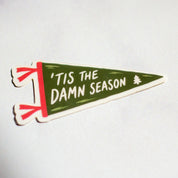 'Tis the Damn Season pennant sticker on marble