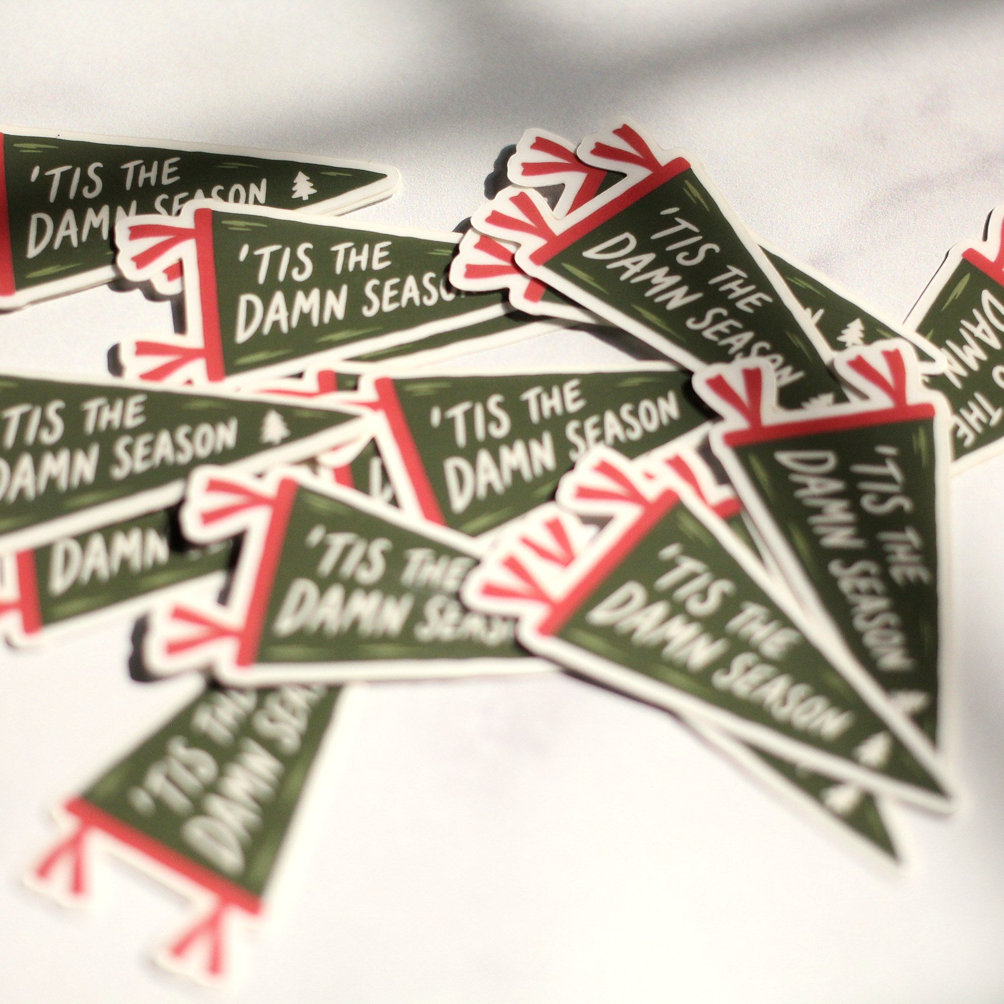 Pile of 'Tis the Damn Season pennant stickers